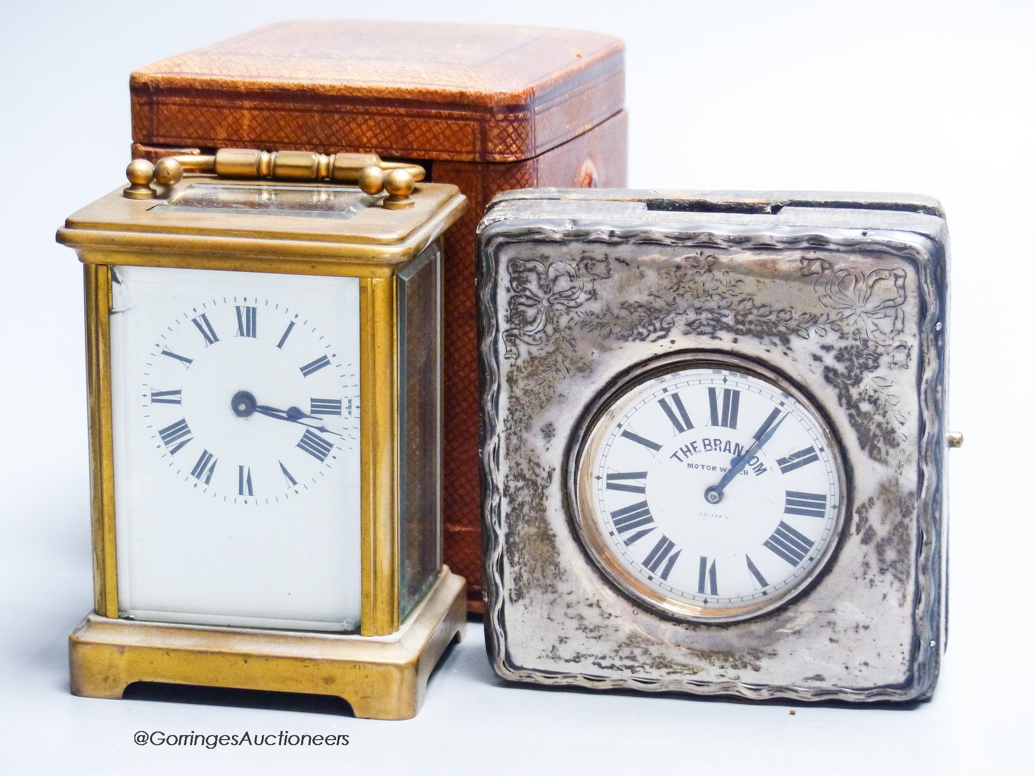 A cased carriage clock and a silver mounted motorwatch